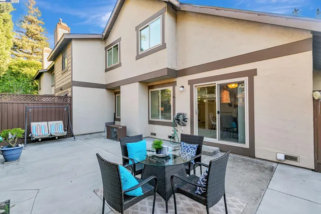 a view of a chairs and table in the back yard of the house