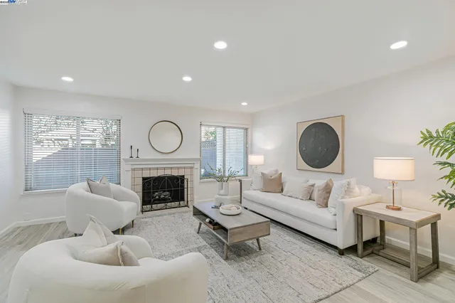 a living room with furniture a fireplace and a floor to ceiling window