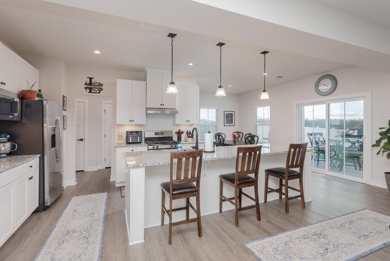 2754 Rdg Hvn Drive Harrisonburg, VA 22801 - Photo 16 of 64 a kitchen with stainless steel appliances kitchen island granite countertop a dining table chairs and white cabinets