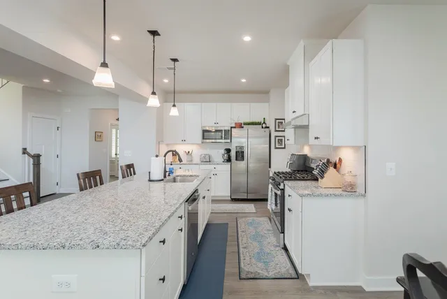 a kitchen with granite countertop a sink stove and cabinets