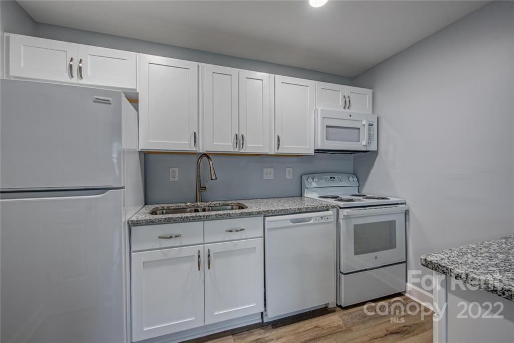 1048 Avondale Road, Unit 14 Lowell, NC 28098 - Photo 5 of 11 a kitchen with granite countertop white cabinets and white appliances