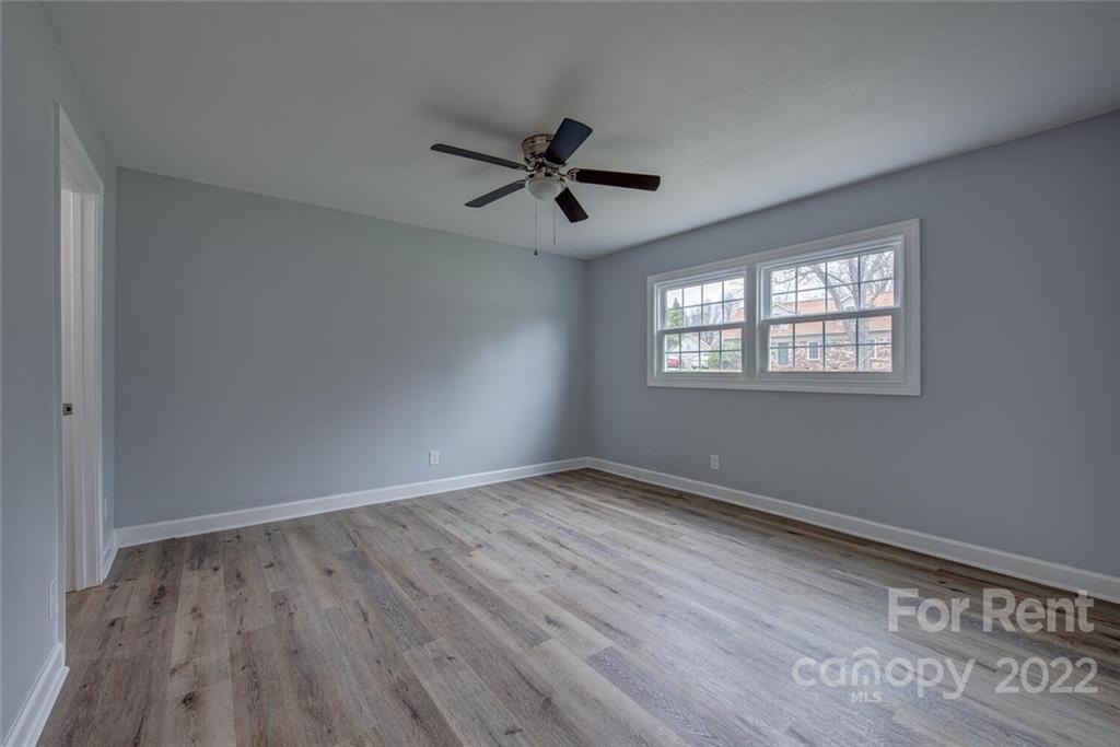 1048 Avondale Road, Unit 14 Lowell, NC 28098 - Photo 9 of 11 an empty room with wooden floor ceiling fan and windows