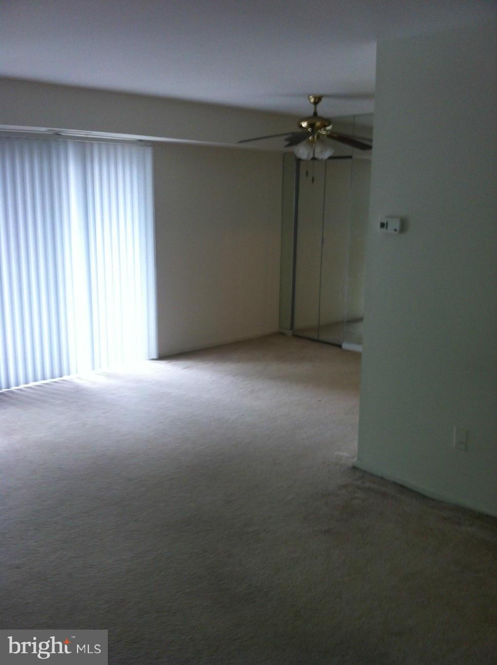 6147 Edsall Road, Unit H Alexandria, VA 22304 - Photo 4 of 13 an empty room with a empty space and a ceiling fan