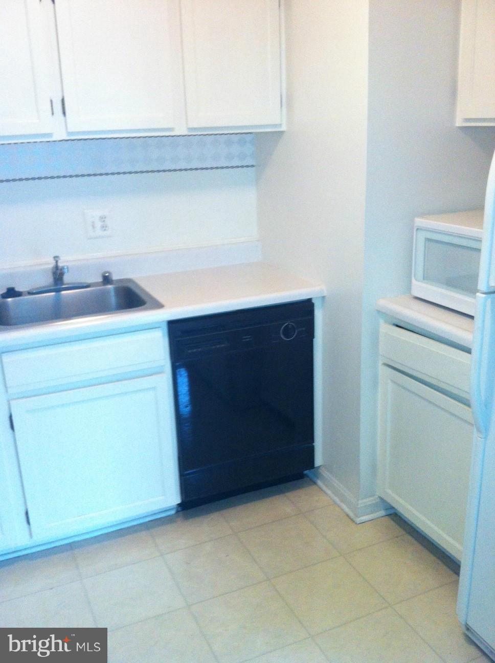 6147 Edsall Road, Unit H Alexandria, VA 22304 - Photo 5 of 13 a room with a cabinets and a stove top oven