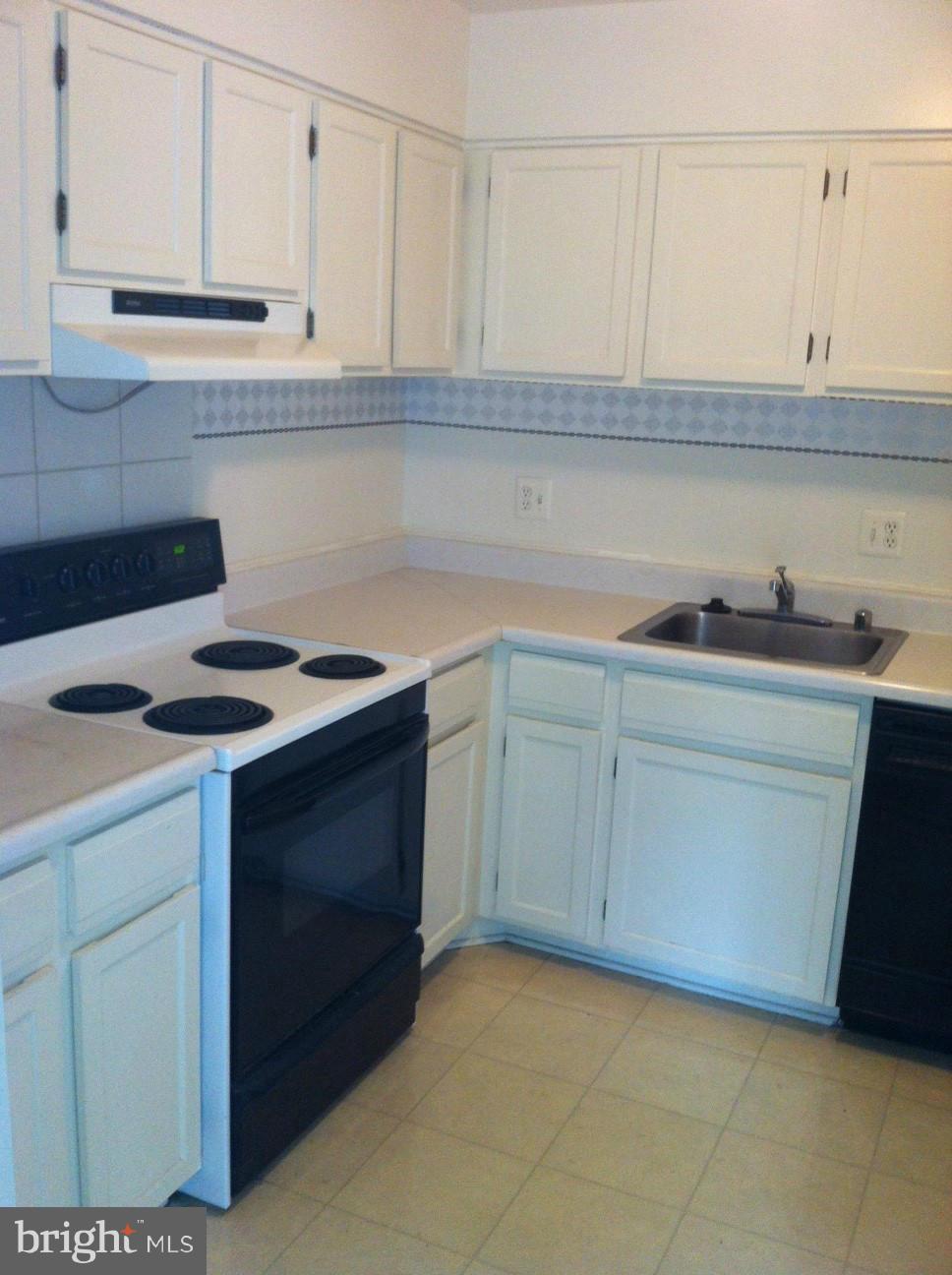 6147 Edsall Road, Unit H Alexandria, VA 22304 - Photo 6 of 13 a kitchen with white cabinets and sink