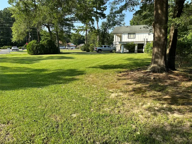 a view of a big house with a big yard and large trees