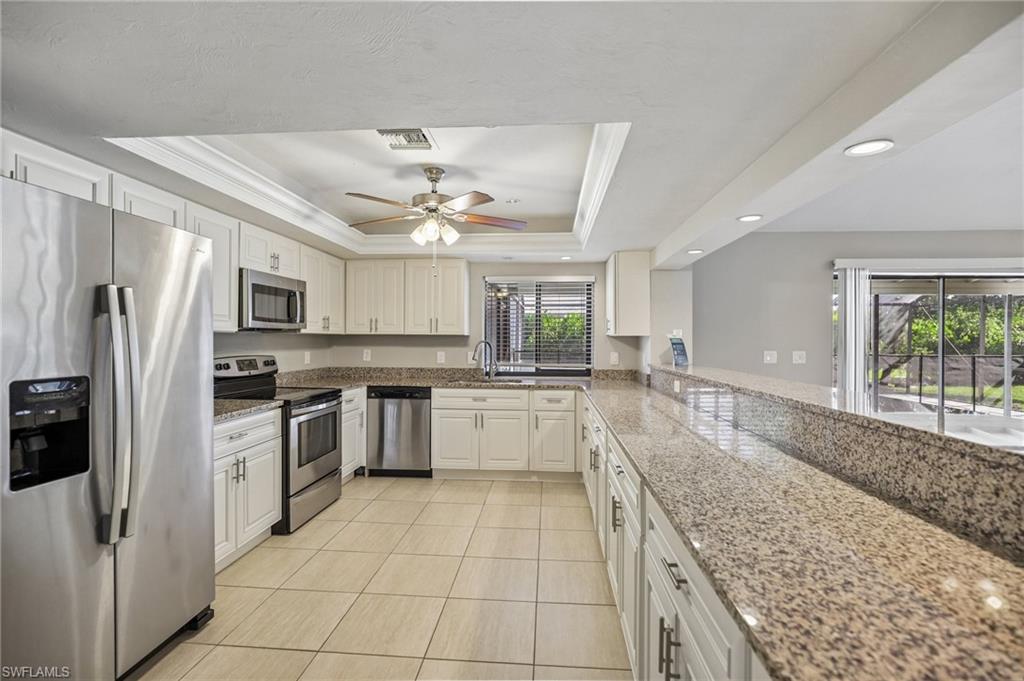 1937 Princess Court Naples, FL 34110 - Photo 17 of 42 a large white kitchen with cabinets a sink and stainless steel appliances
