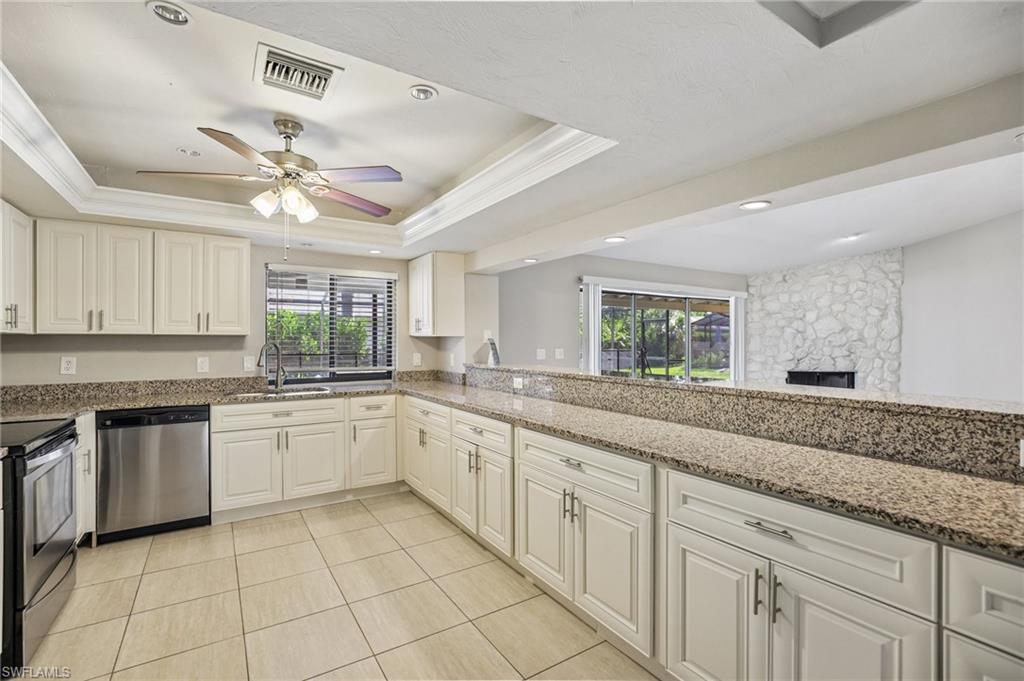 1937 Princess Court Naples, FL 34110 - Photo 18 of 42 a kitchen with granite countertop white cabinets white appliances with a sink and dishwasher