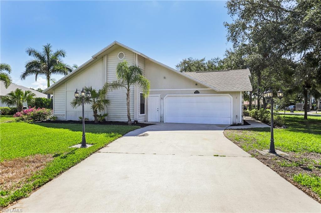 1937 Princess Court Naples, FL 34110 - Photo 2 of 42 a front view of a house with a yard and garage