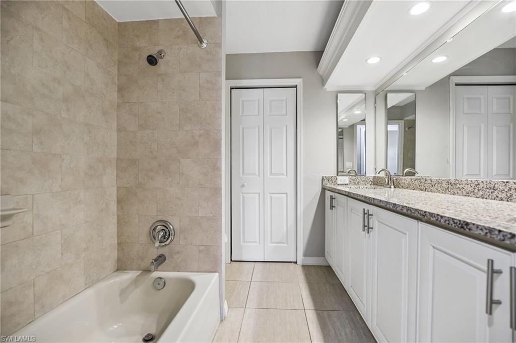 1937 Princess Court Naples, FL 34110 - Photo 27 of 42 a bathroom with a granite countertop sink a mirror and a bathtub
