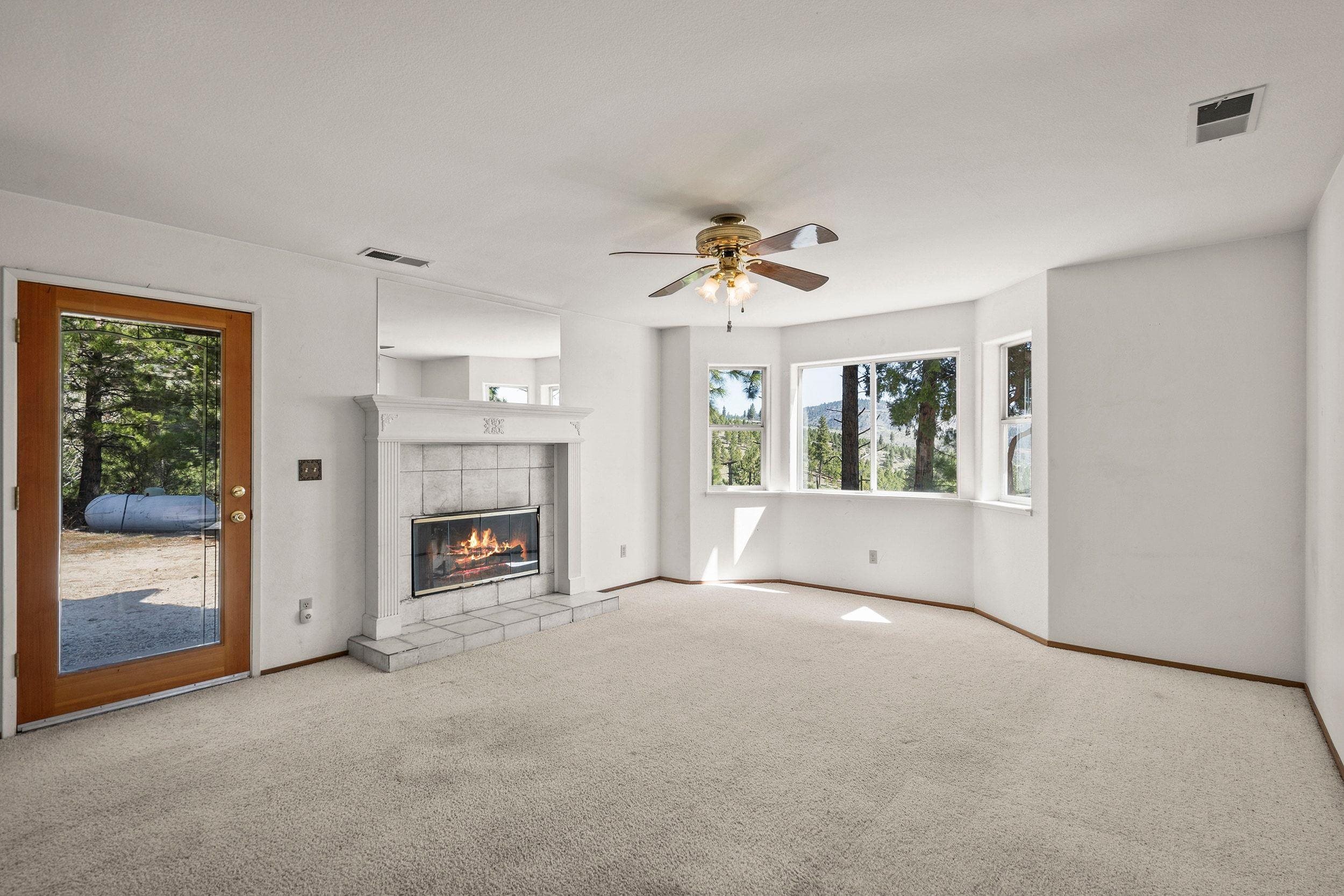 1020 Sunrise Creek Road Loyalton, CA 96118 - Photo 8 of 27 a view of an empty room with a fireplace and a window