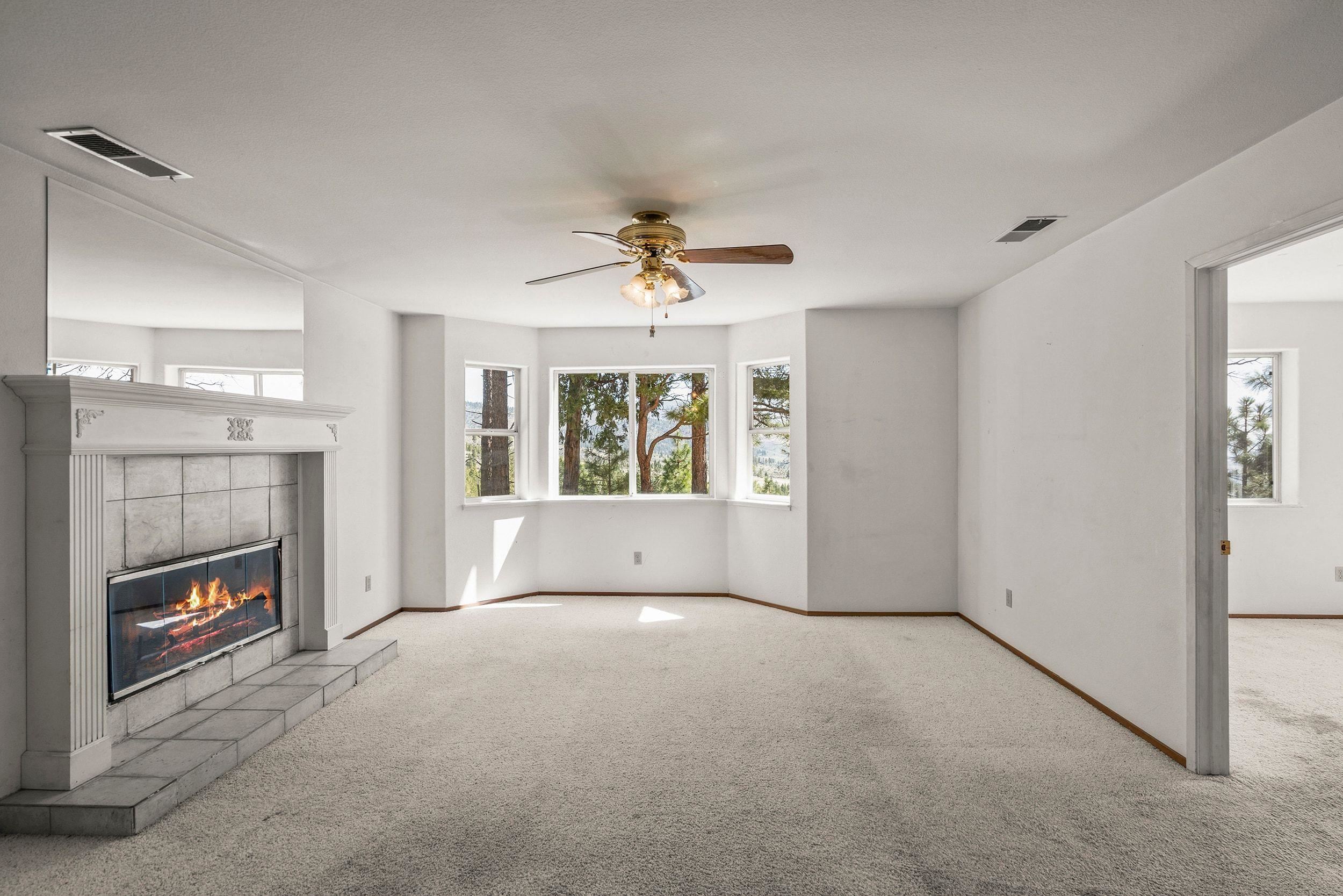 1020 Sunrise Creek Road Loyalton, CA 96118 - Photo 9 of 27 a view of an empty room with a fireplace and a window