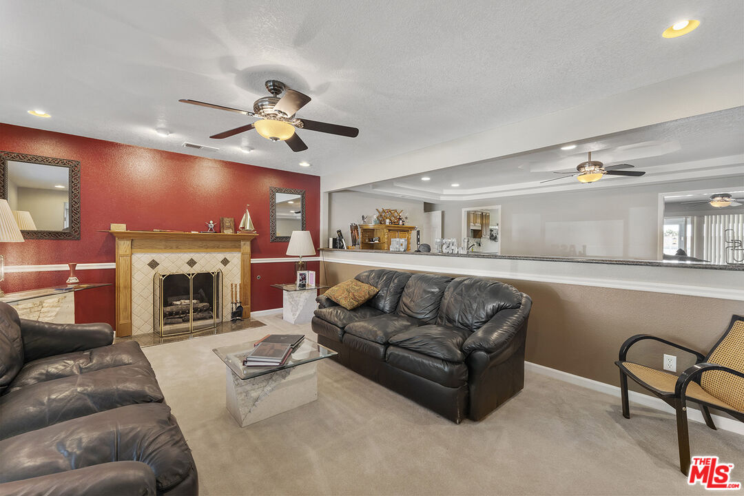 8391 Hillside Road Rancho Cucamonga, CA 91701 - Photo 36 of 51 a living room with furniture a fireplace and a flat screen tv