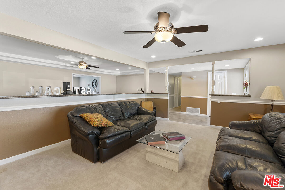8391 Hillside Road Rancho Cucamonga, CA 91701 - Photo 37 of 51 a living room with furniture a fireplace and a flat screen tv