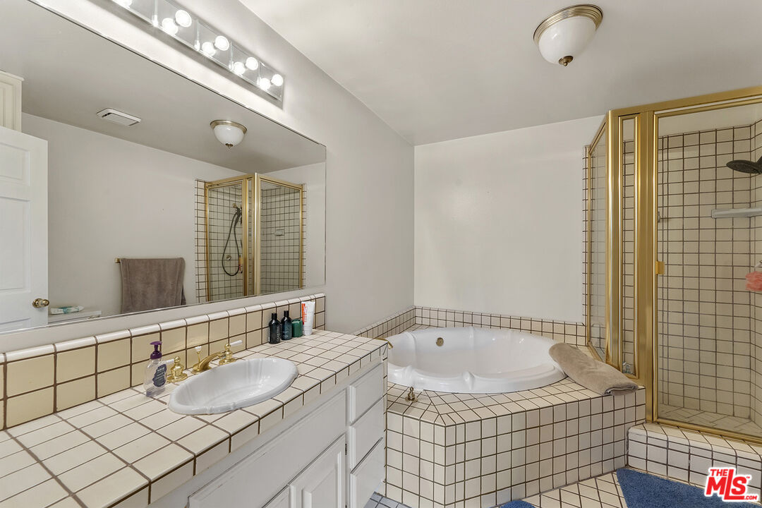 8391 Hillside Road Rancho Cucamonga, CA 91701 - Photo 45 of 51 a view of bathroom with a tub shower and mirror