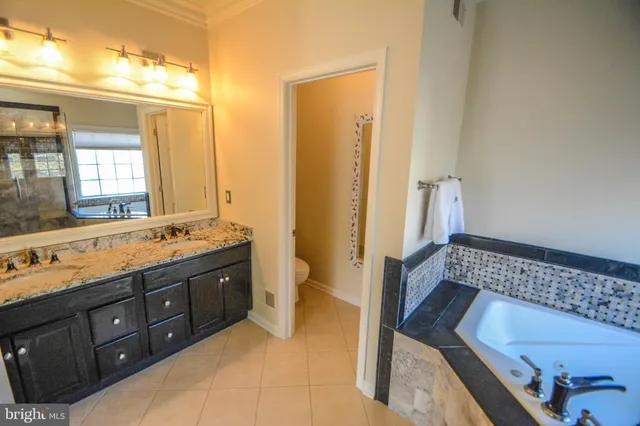 a spacious bathroom with a tub sink and mirror