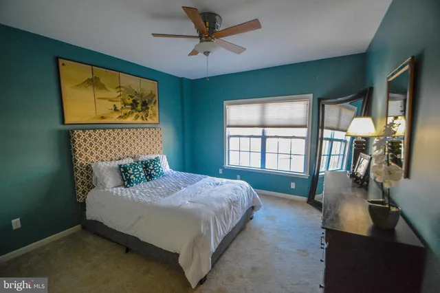 a bedroom with a bed a window and dresser