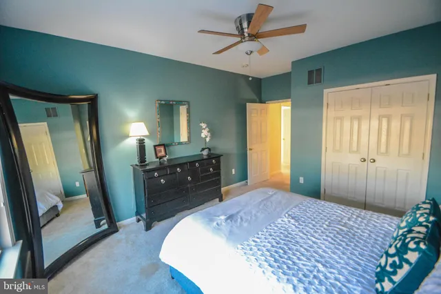 a bedroom with a bed and a mirror on dresser