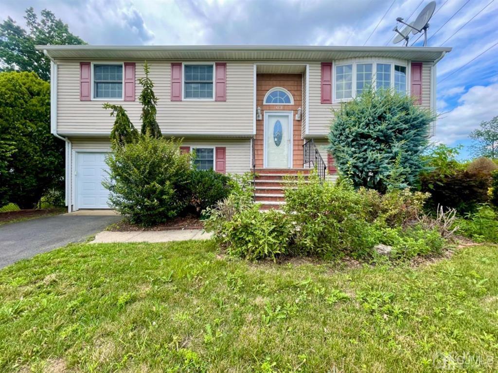 63 Dalton Place Edison, NJ 08817 - Photo 1 of 31 a front view of a house with a yard and garage