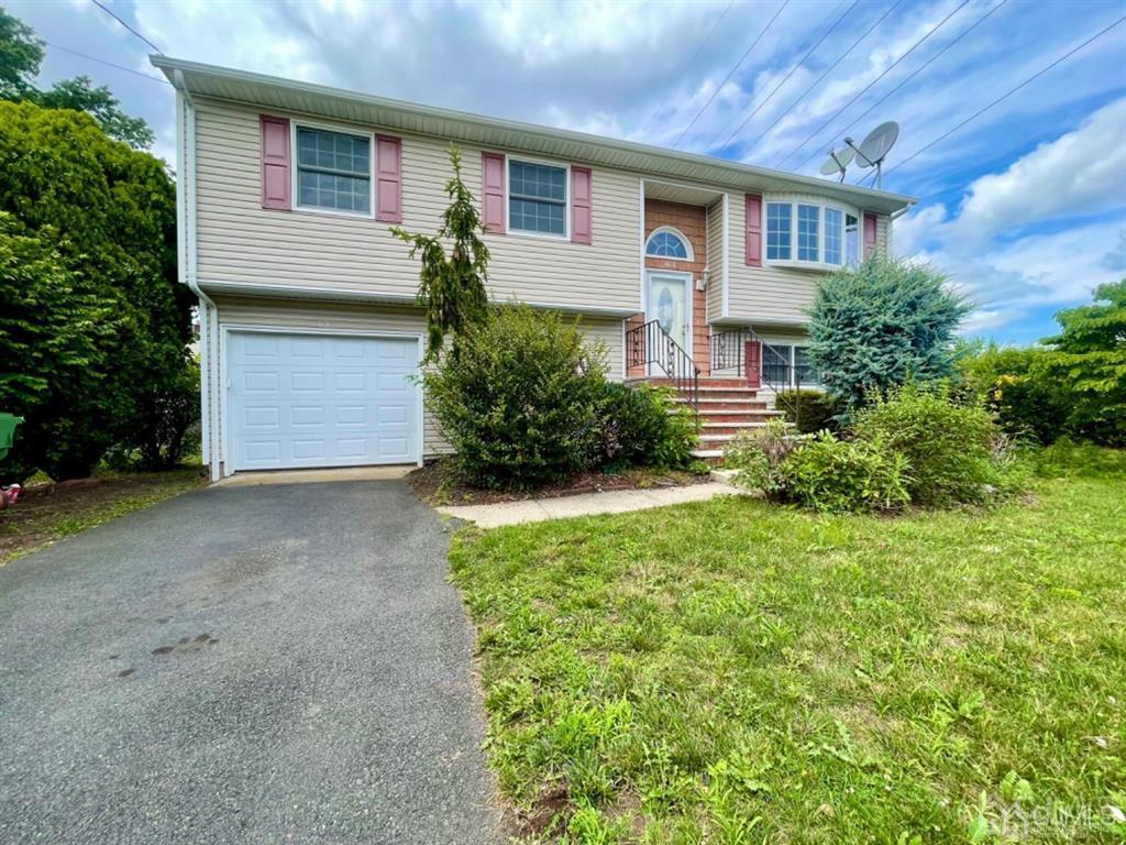 63 Dalton Place Edison, NJ 08817 - Photo 2 of 31 a front view of a house with a yard and garage
