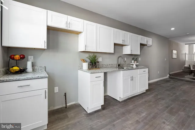 a kitchen with white cabinets stainless steel appliances and sink
