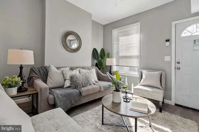 a living room with furniture a clock and a window
