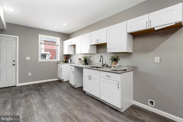 a kitchen with granite countertop white cabinets and white appliances