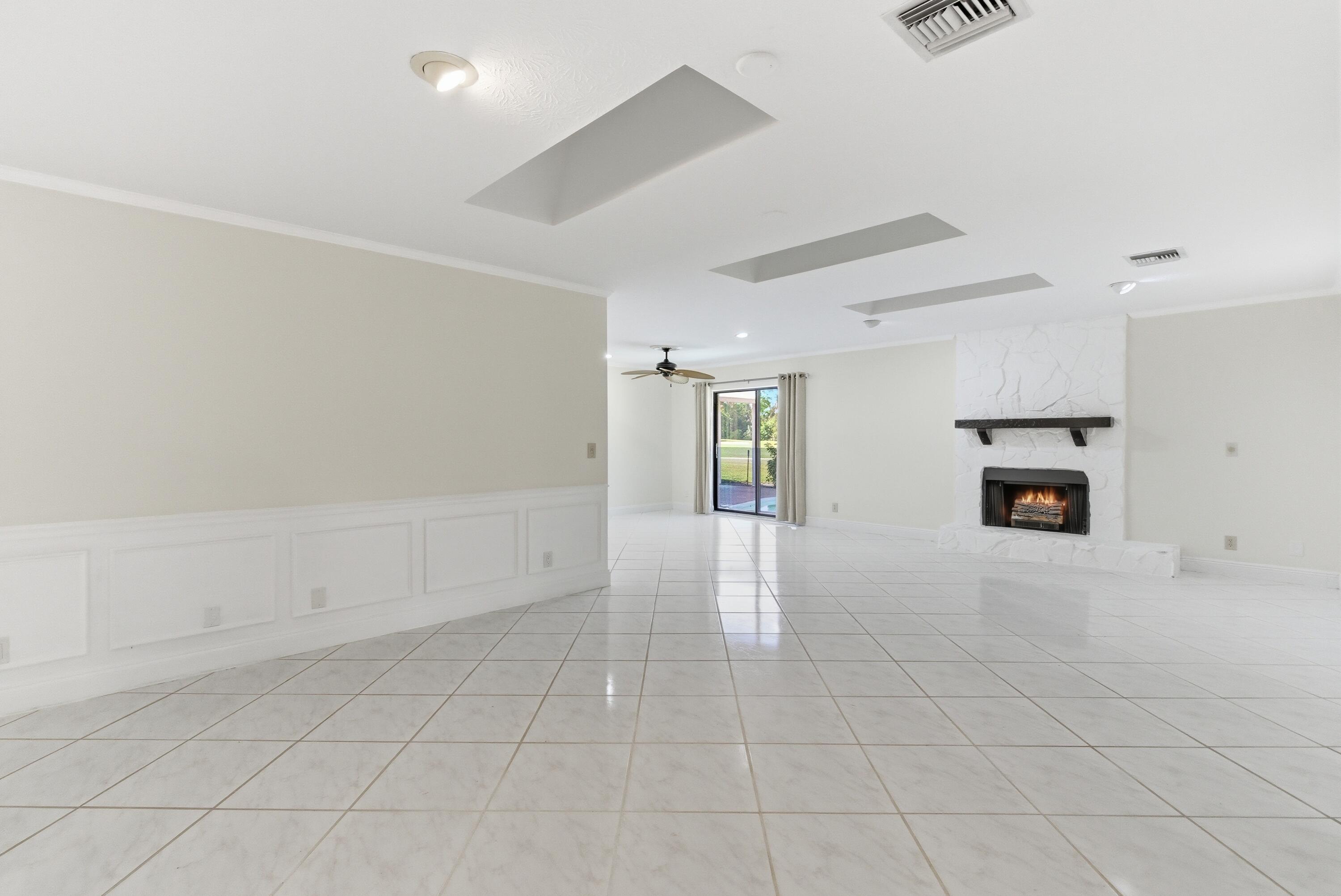 5151 Southeast Burning Tree Circle Stuart, FL 34997 - Photo 17 of 74 an empty room with windows and fireplace