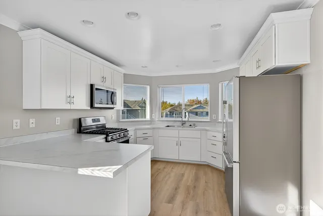 a kitchen with stainless steel appliances a refrigerator sink and microwave