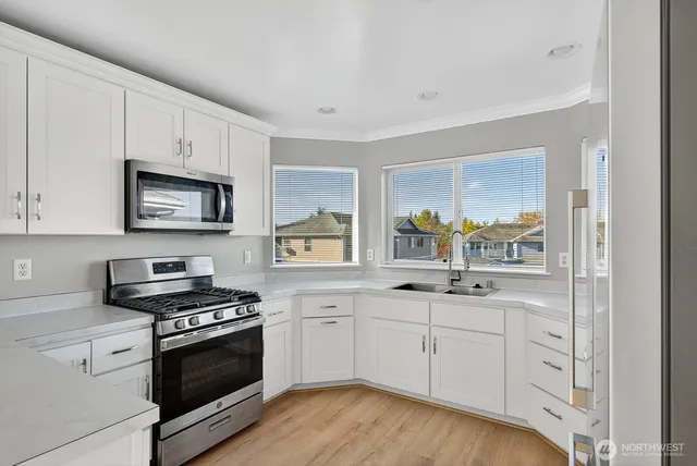 a kitchen with white cabinets appliances and sink
