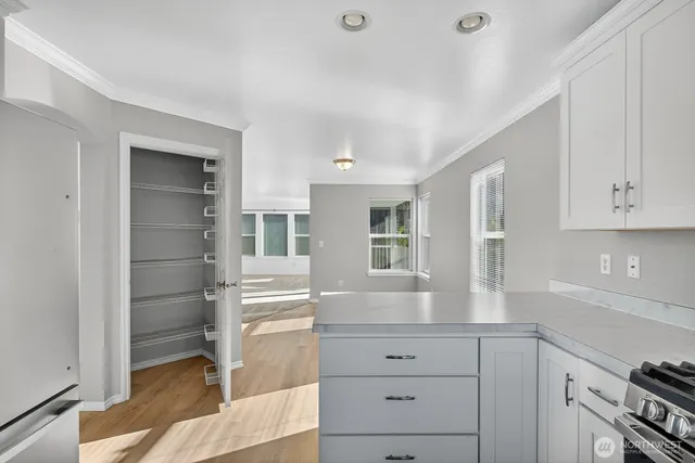 a kitchen with white cabinets and window