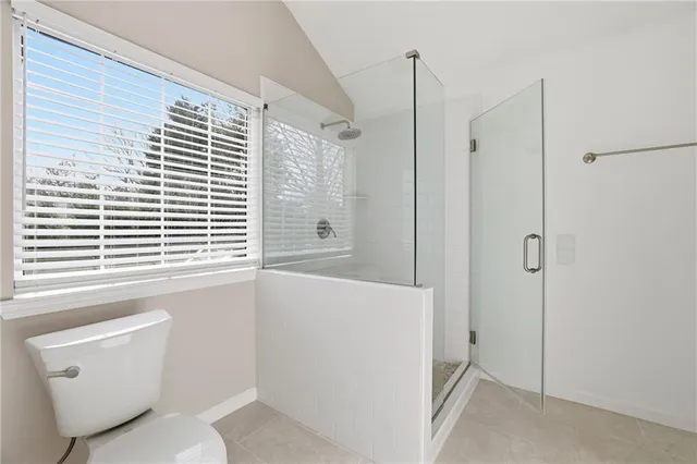 a bathroom with a window a toilet and a shower