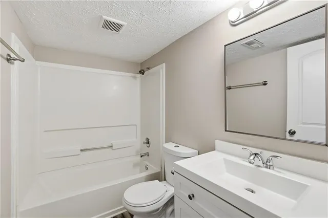 a bathroom with a toilet a sink a mirror a shower and vanity