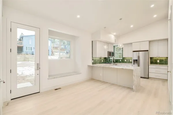 a kitchen with kitchen island a counter top space a refrigerator and cabinets