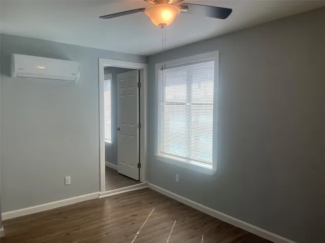 an empty room with closet and windows