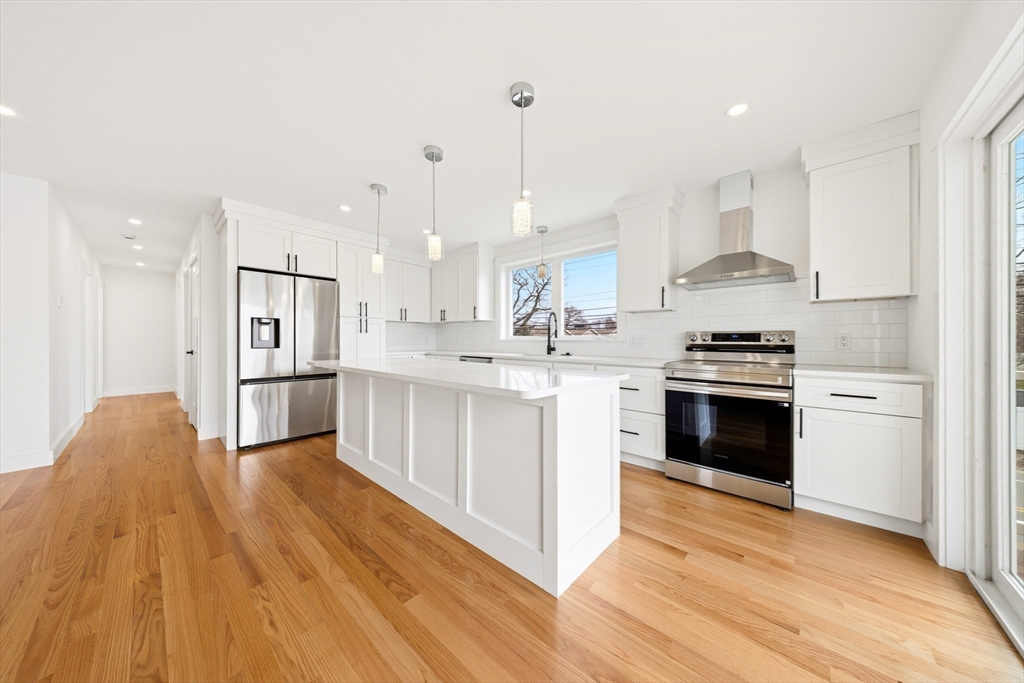 2 Old County Road, Unit 12 Salisbury, MA 01952 - Photo 3 of 29 a kitchen with stainless steel appliances kitchen island wooden floors and white cabinets