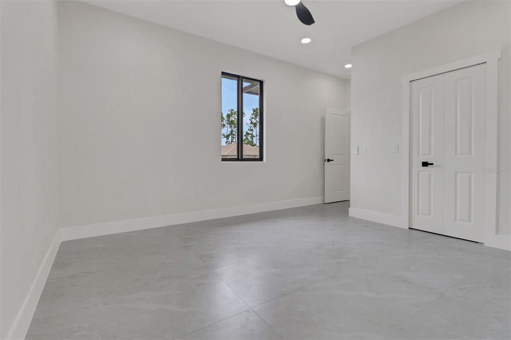 4501 15th Street Southwest Lehigh Acres, FL 33973 - Photo 14 of 40 an empty room with a ceiling fan and windows