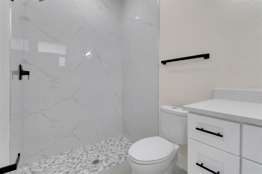 4501 15th Street Southwest Lehigh Acres, FL 33973 - Photo 16 of 40 a white toilet sitting next to a shower