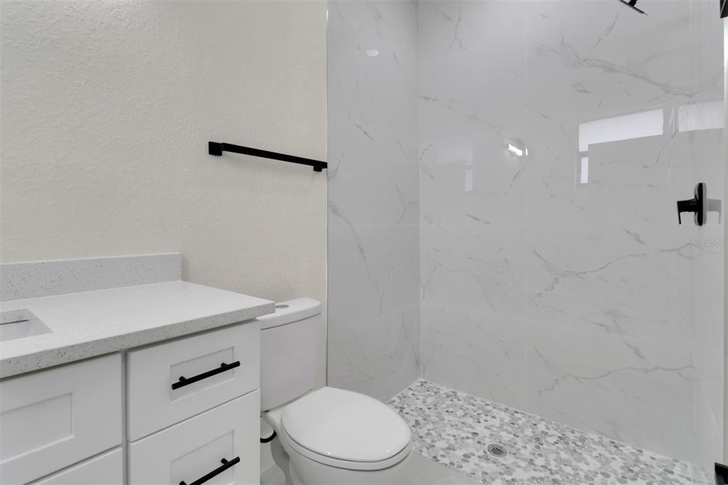 4501 15th Street Southwest Lehigh Acres, FL 33973 - Photo 35 of 40 a bathroom with a sink a toilet and vanity