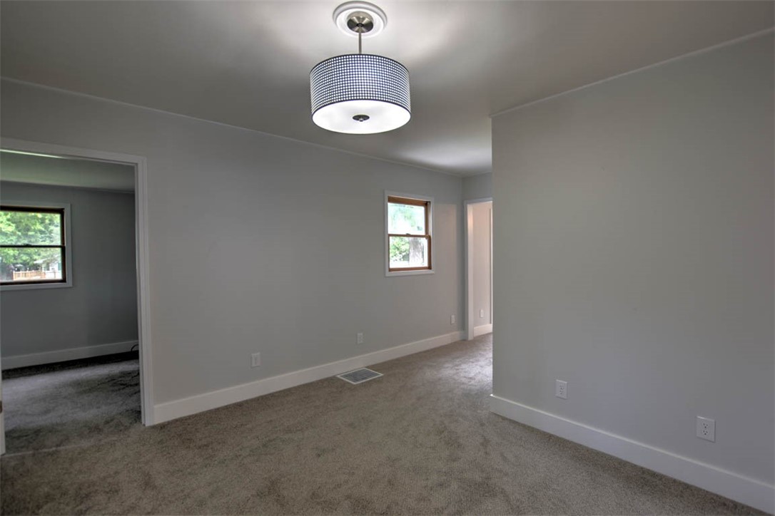 33 Lake Grove Club Decatur, IL 62521 - Photo 13 of 24 an empty room with a chandelier fan and windows