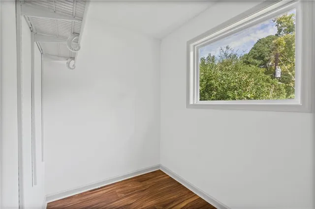 a view of a small space with wooden floor and a window