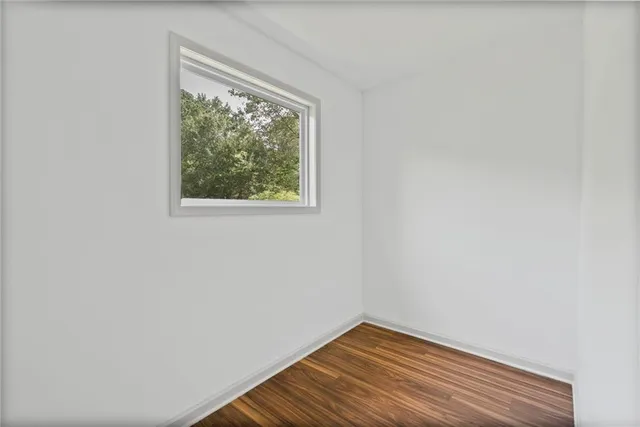 a view of a small space with wooden floor and a window