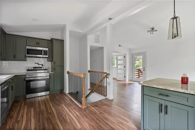 a kitchen with granite countertop a sink appliances and cabinets
