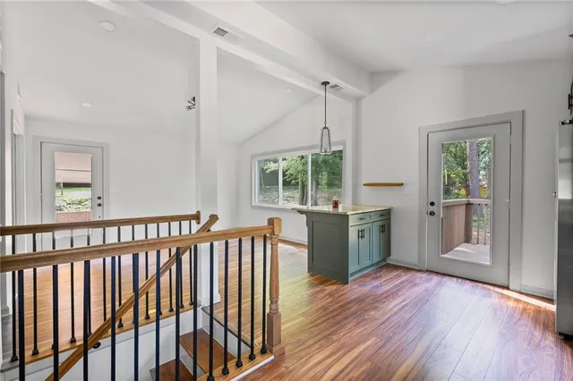 a kitchen with wooden floors and windows