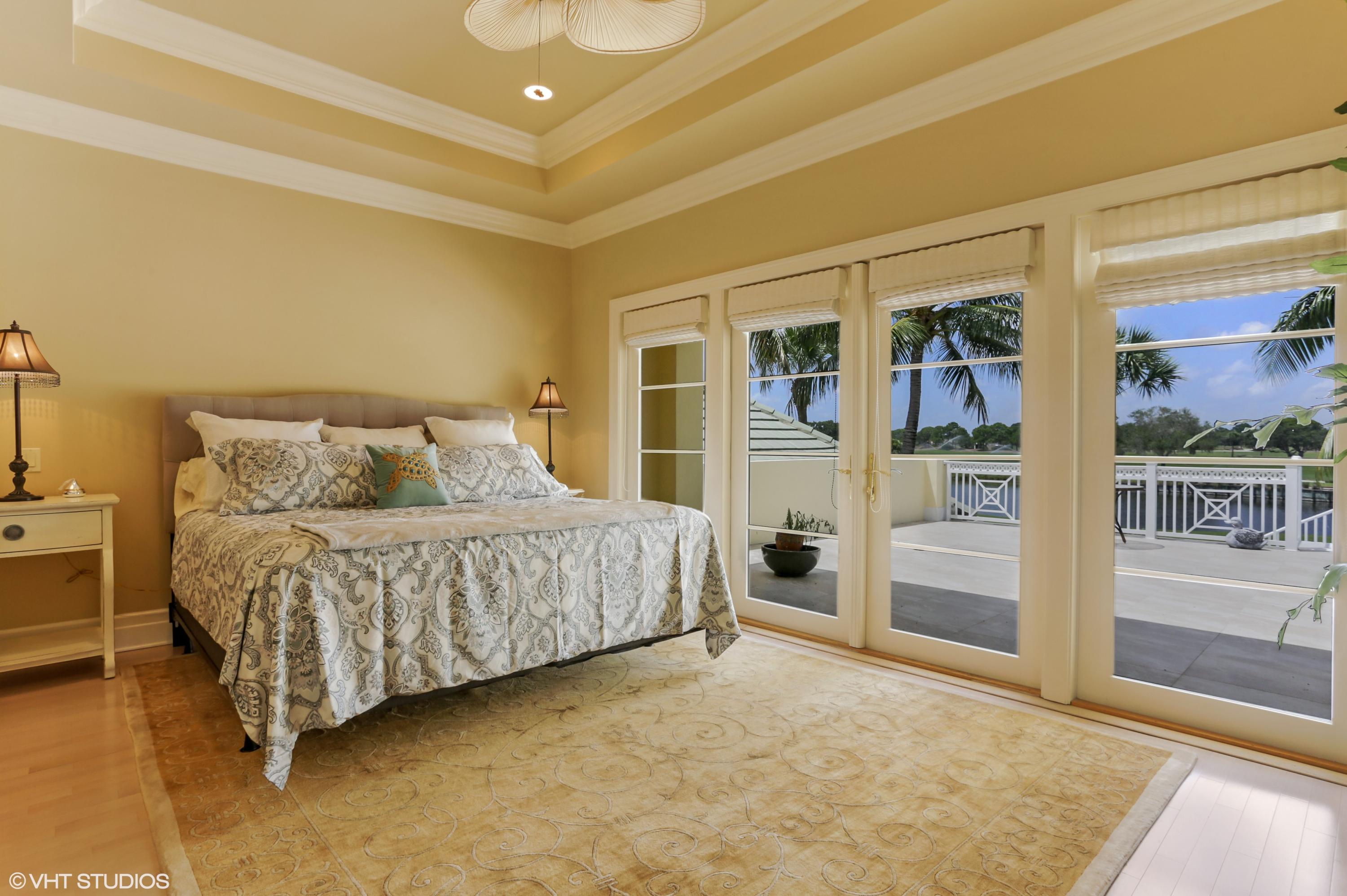 119 Terrapin Trail Jupiter, FL 33458 - Photo 24 of 41 a spacious bedroom with a bed and glass door