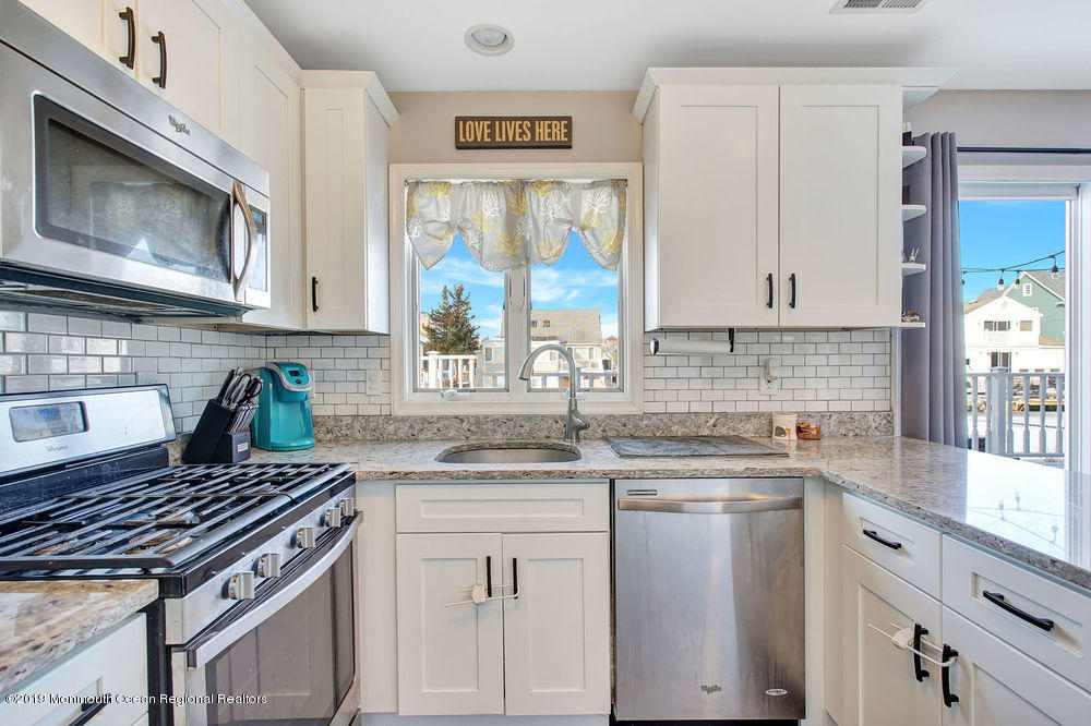 719 Drum Point Road Brick, NJ 08723 - Photo 9 of 37 a kitchen with stainless steel appliances granite countertop a sink stove and cabinets