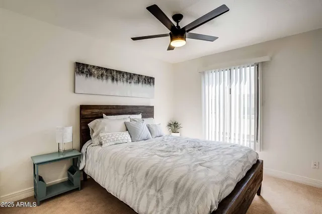 a bedroom with a bed and a chandelier fan