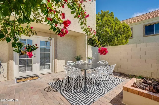 a backyard of a house with table and chairs