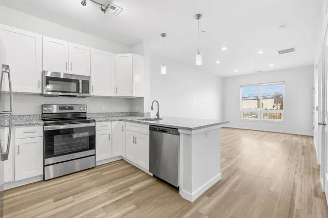a kitchen with stainless steel appliances a stove a sink and a refrigerator