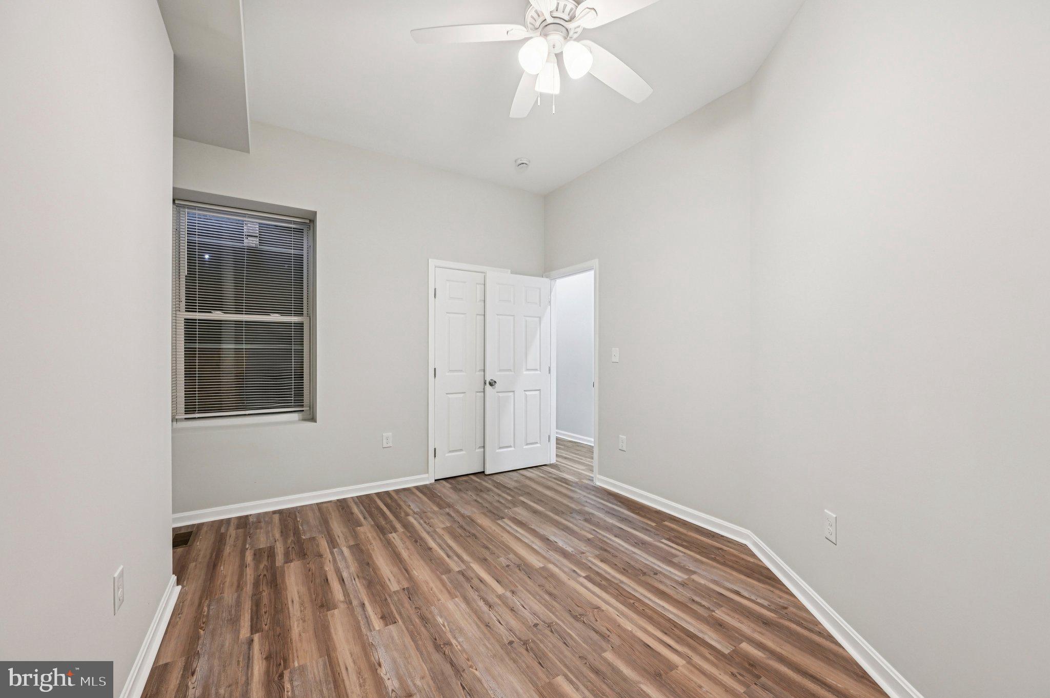 750 Reservoir Street, Unit A Baltimore, MD 21217 - Photo 18 of 23 an empty room with wooden floor chandelier fan and windows